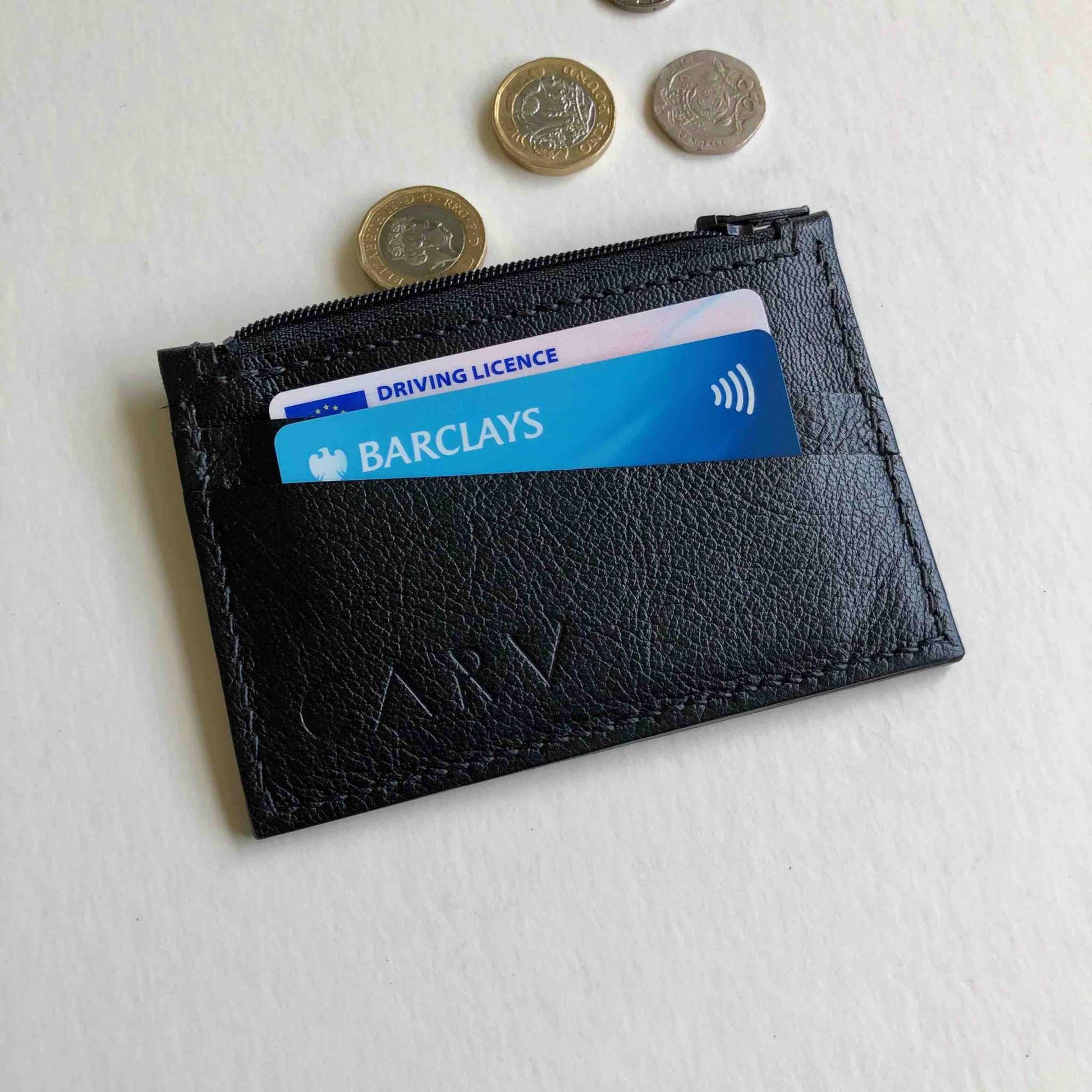 Zipped Leather Card Holder in Black, showcasing minimalist design with card slots and zipper pocket.