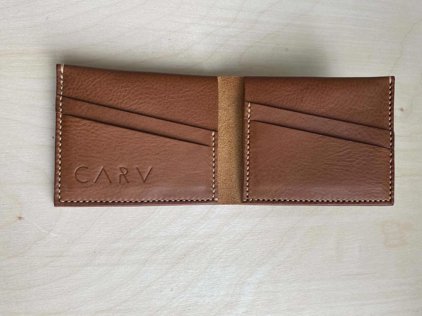 Handmade tan leather wallet with card slots and stitched detailing.