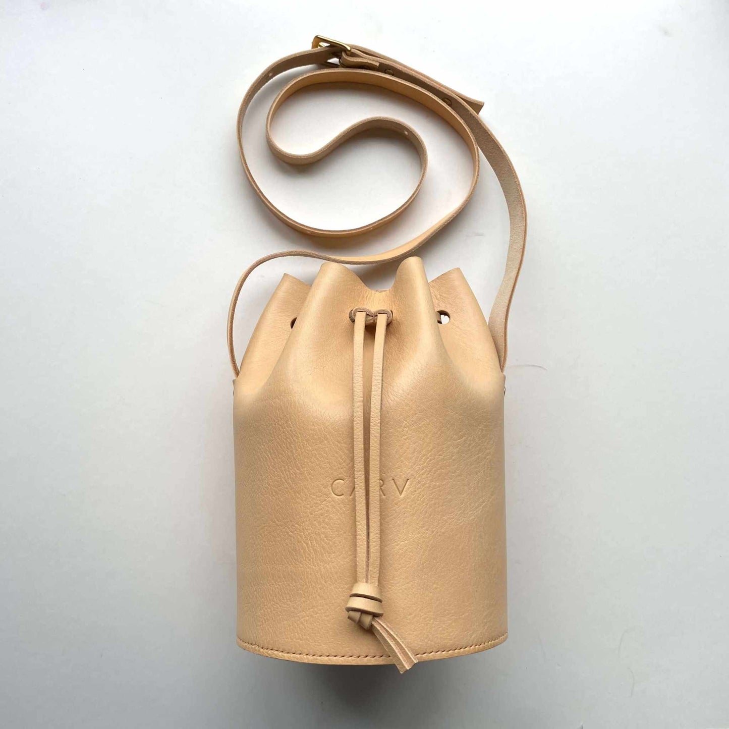 Cylinder Leather Bucket Bag in natural leather with adjustable strap and minimalist design by CARV.