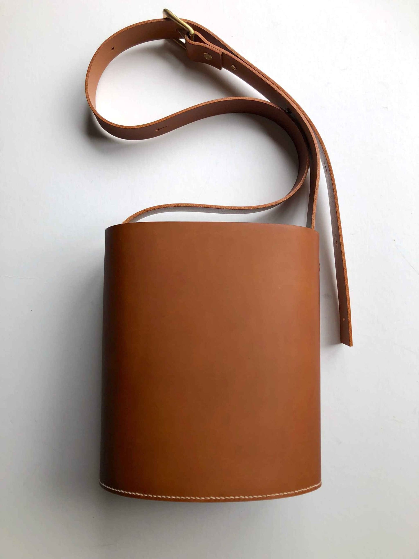 Oval Midi Leather Bag in tan, sustainable and handcrafted in the UK, with adjustable strap and zip closure.