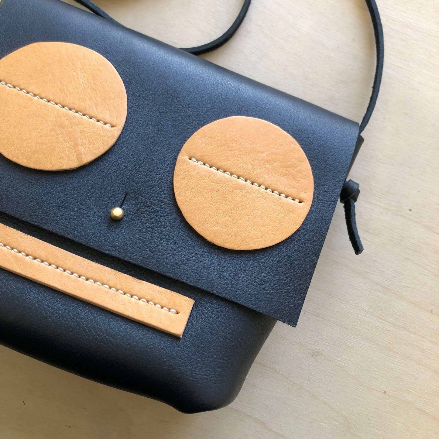 Little Robot Crossbody Bag made from black full grain leather with natural leather accents, featuring a playful robot face design.