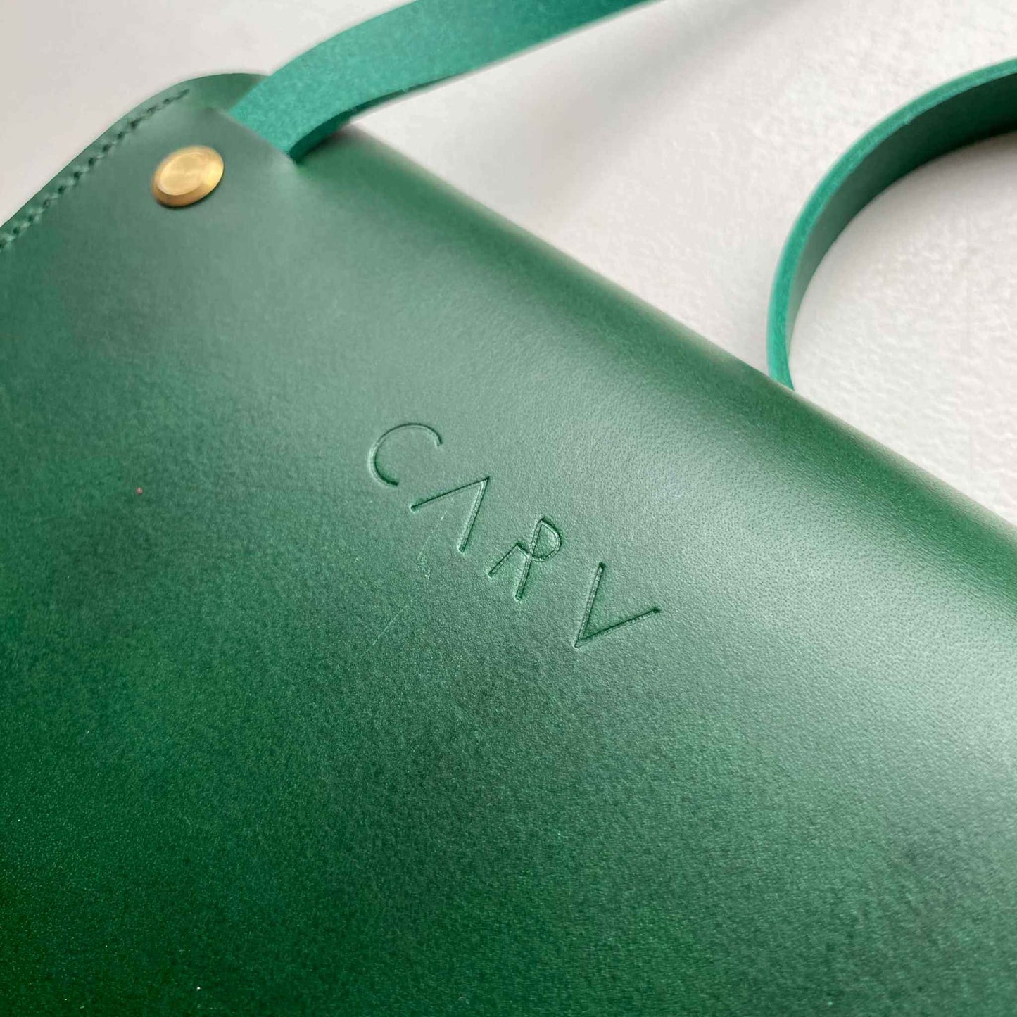 Pioneer Mini Green Leather Crossbody Bag with adjustable strap and embossed branding.