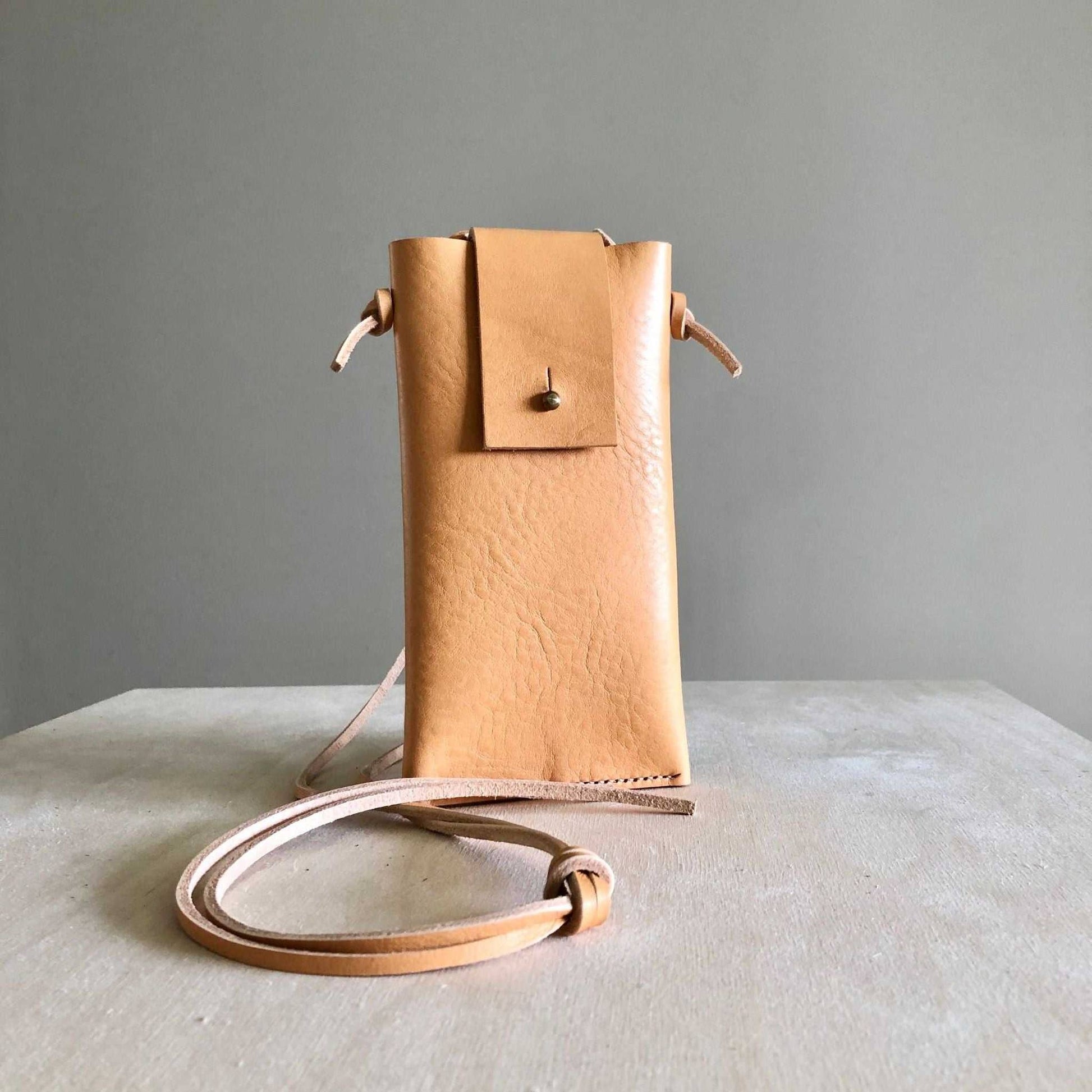 Knot Leather Crossbody Phone Bag in natural leather with adjustable strap on neutral background.