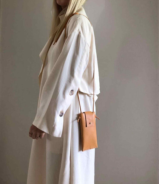 Knot Leather Crossbody Phone Bag in natural leather worn over the shoulder.