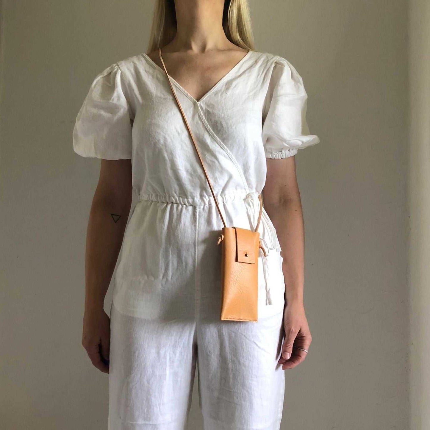 Knot Leather Crossbody Phone Bag worn as neck pouch in natural color, sustainable leather.