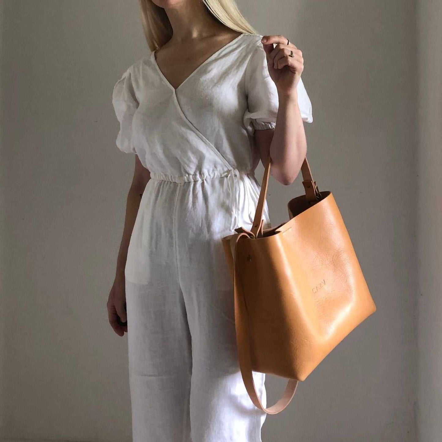 Basket Midi Leather Tote Bag in natural full-grain leather, elegantly worn on shoulder, showcasing timeless minimalist design and British craftsmanship.